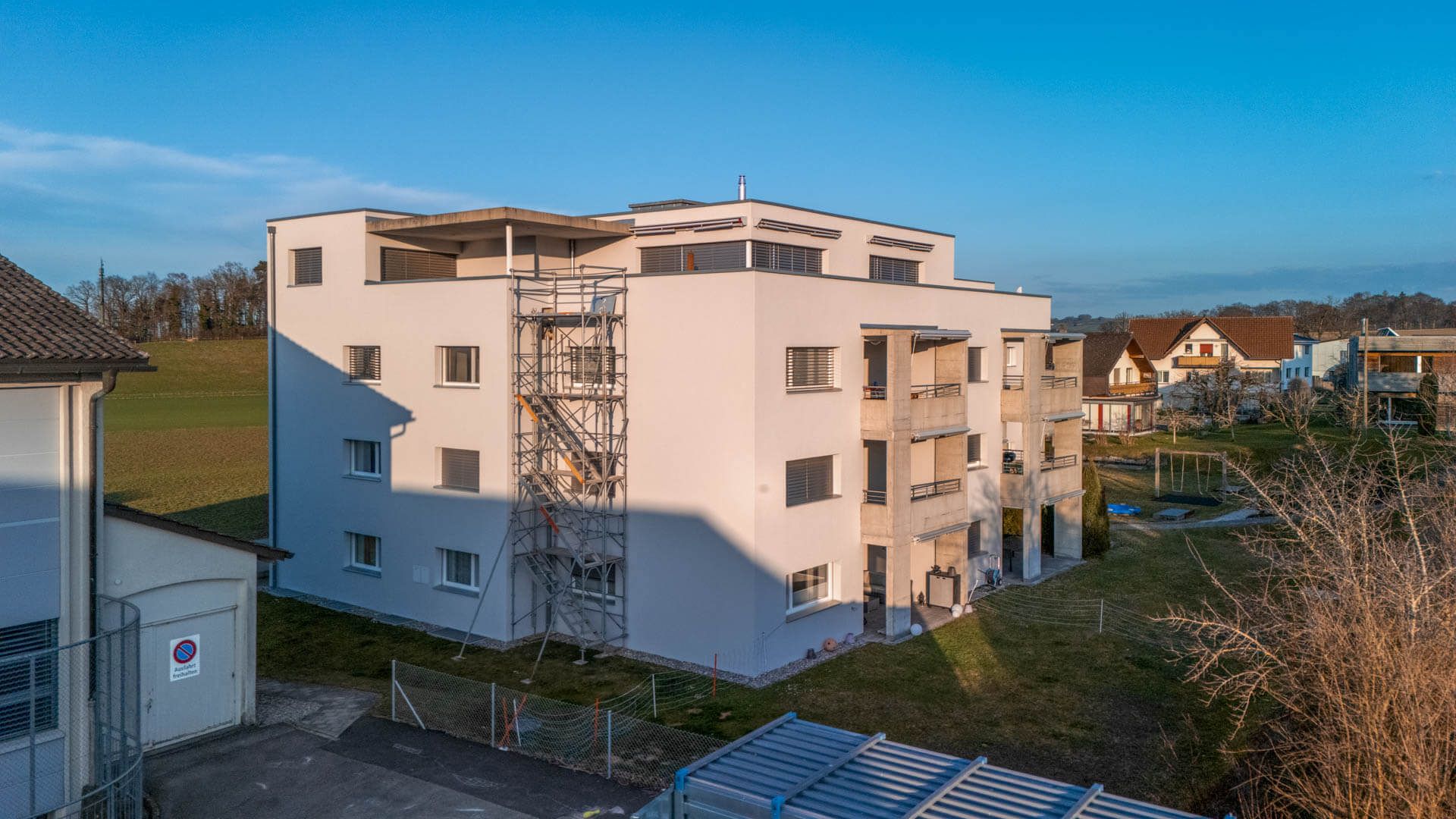 Freistehendes Wohnhaus mit Gerüst, Standfläche auf Rasen statt auf der Strasse – Foto: KUGE Bau AG